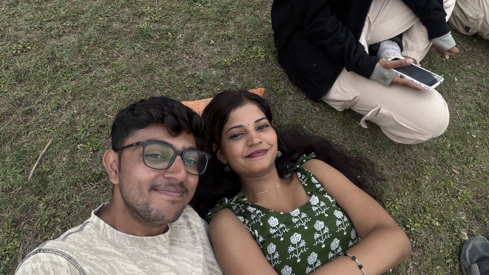 Relaxed top-down couple selfie outdoors.
