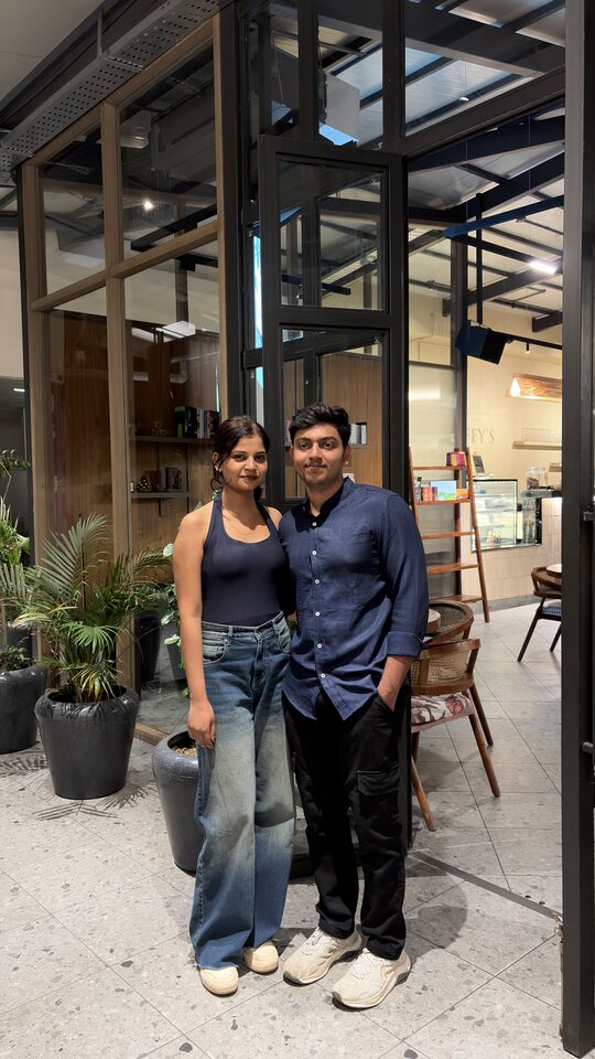 Full-length couple portrait outside a venue.