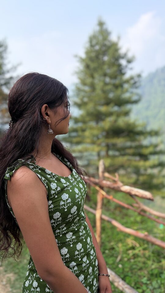 Green-dress outdoor portrait near trees.